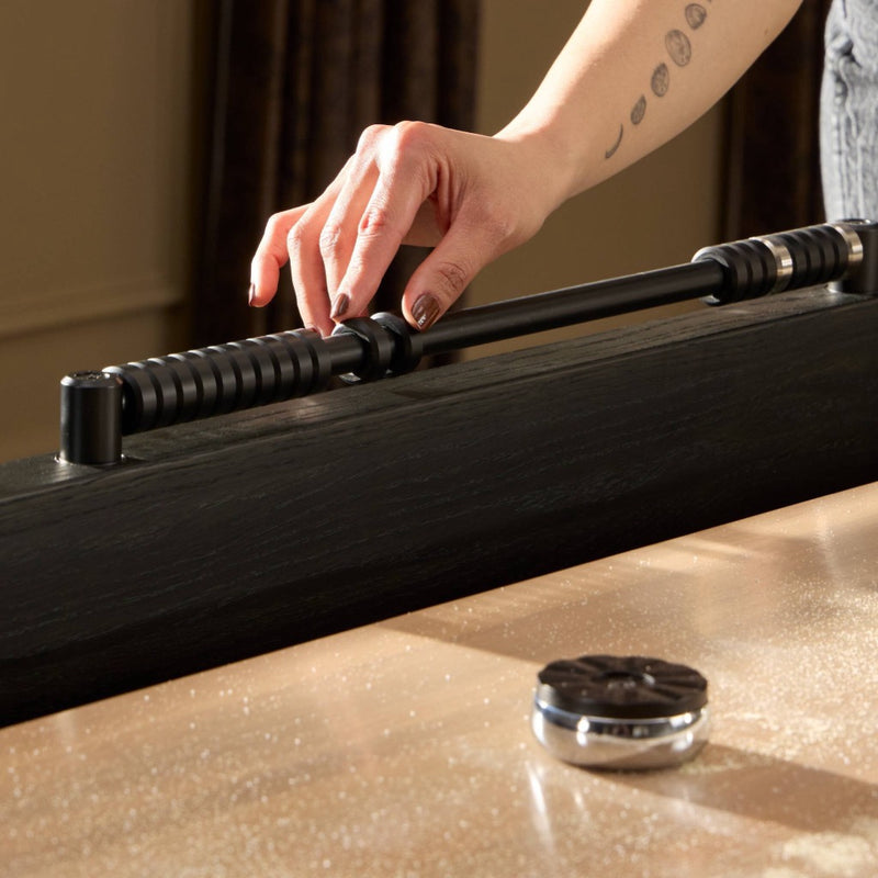 Four Hands District Eight Large Shuffleboard Table puck and hand view 
