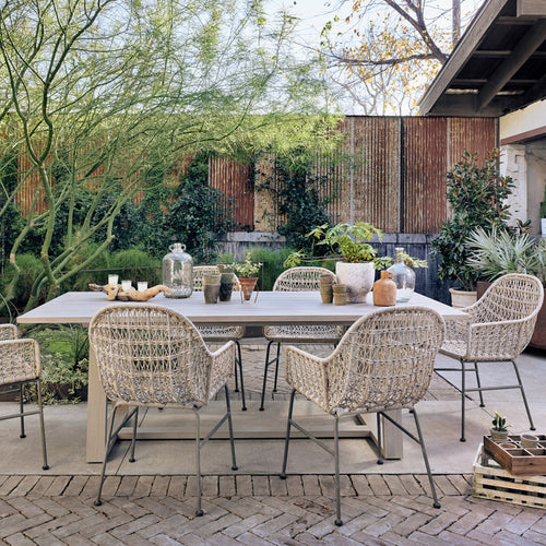Bandera Outdoor Woven Dining Chair life style view in outdoor setting with 6 chairs around a table